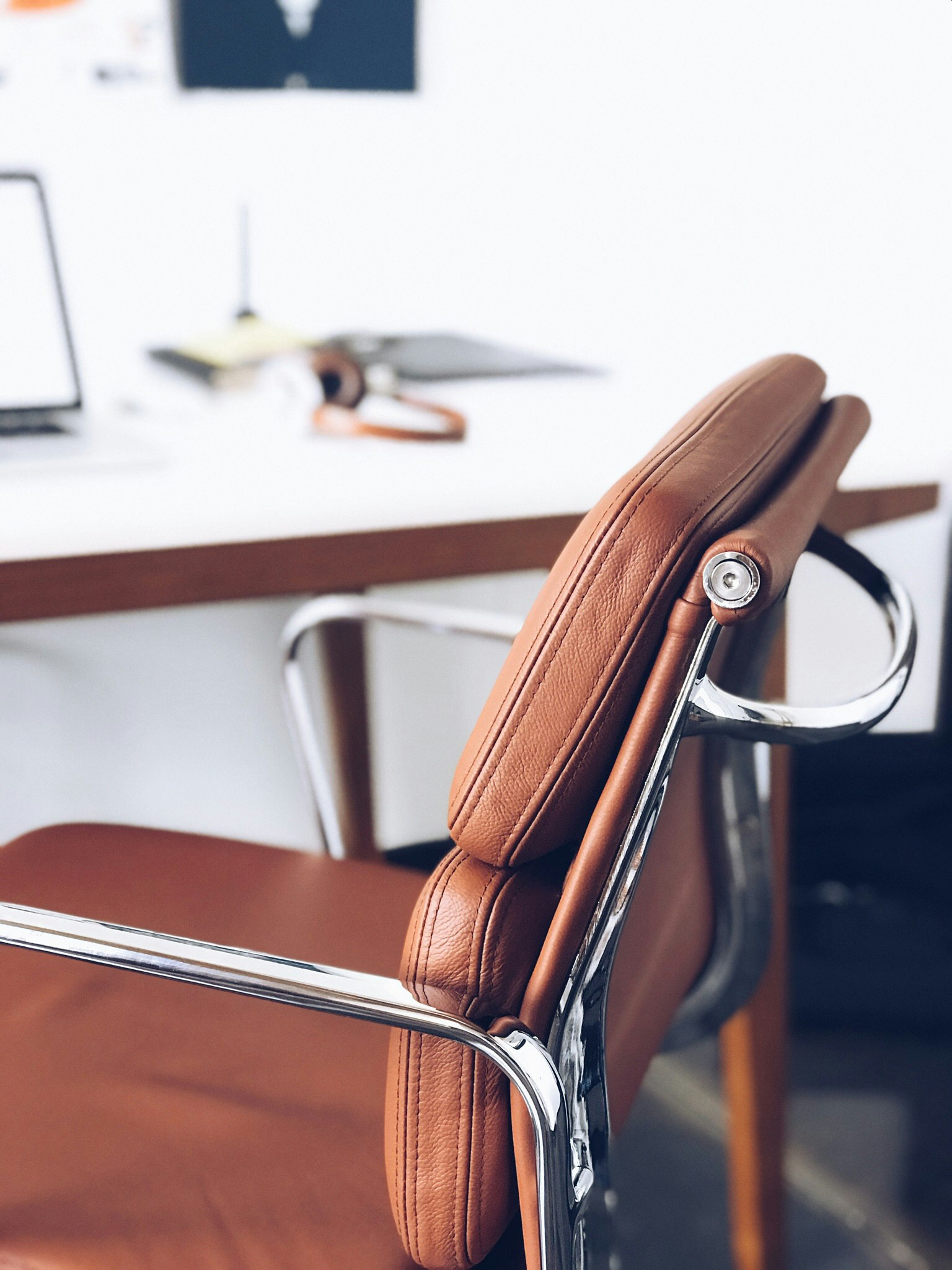 closeup photography of brown leather chair near white table